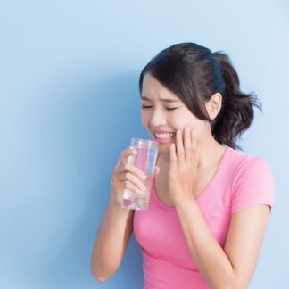 female drinking water with sensitive teeth